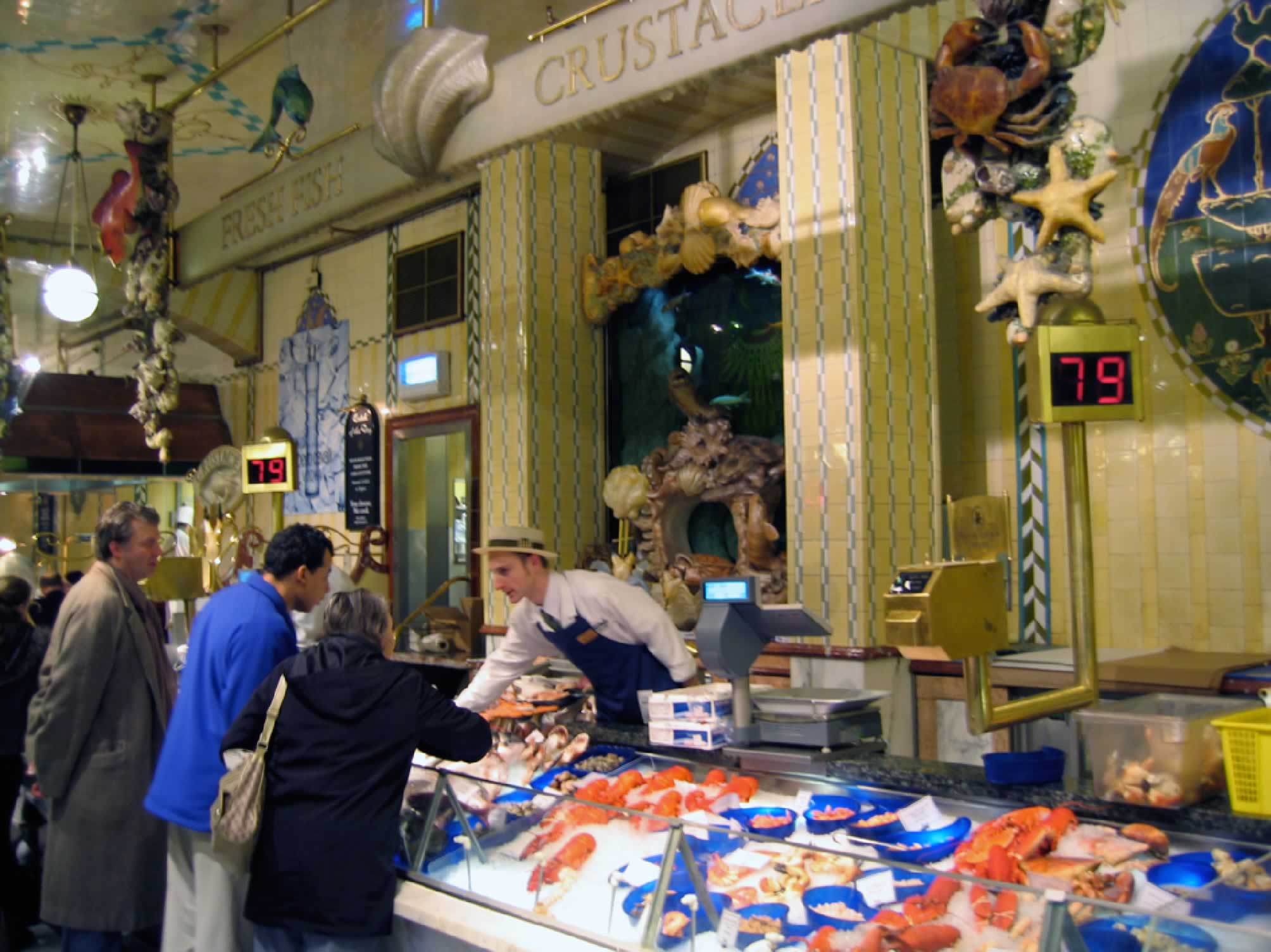 Sam leaning over fish counter to serve customers